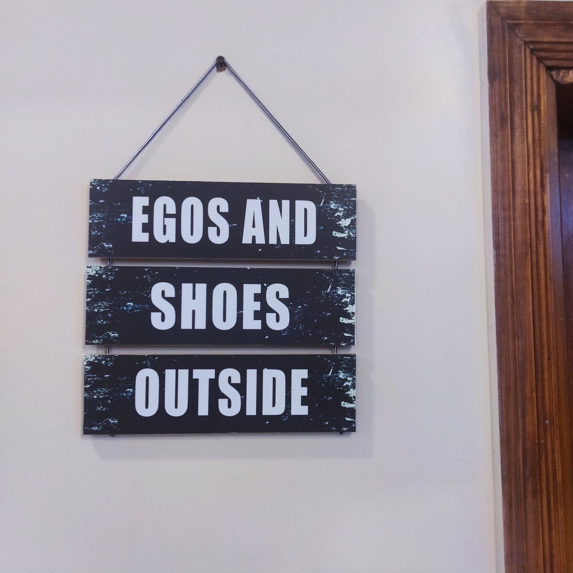 Three steps wooden plates with a quotation Ego and shoes outside for your room