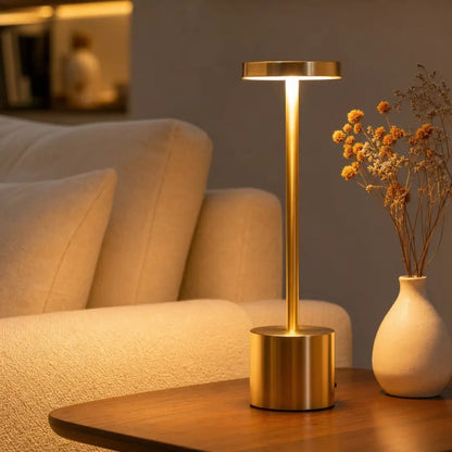 Cordless metal touch lamp gold color on bedside table